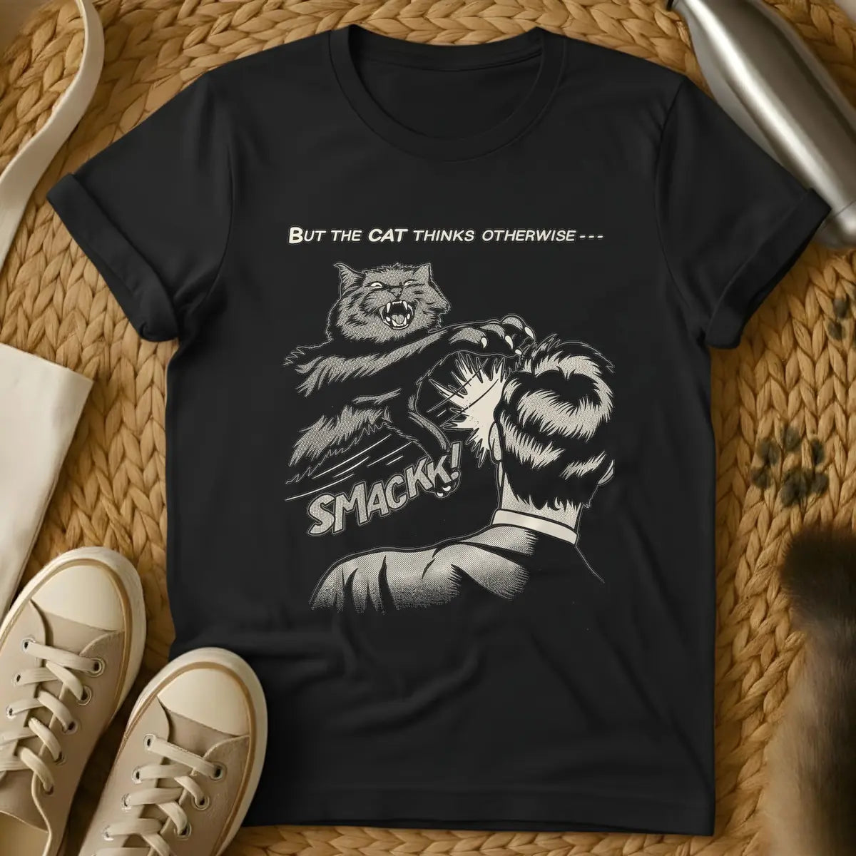Black - Vintage comic book style illustration in beige tones with halftone shading. An angry cat with sharp claws is mid-air, slapping the back of a person's head. Below the action, the word 'SMACKK!' appears in a bold comic font. Above the scene, the text reads 'BUT THE CAT THINKS OTHERWISE ---'.