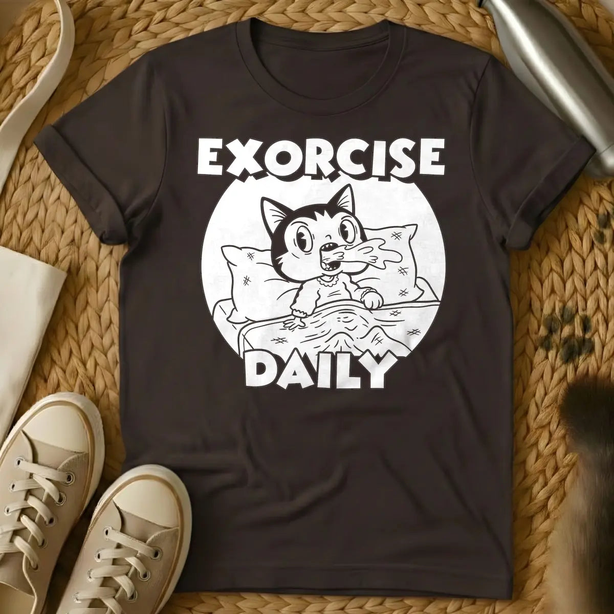Dark Chocolate - T-shirt design of a cartoon cat sleeping comfortably under a blanket with a pillow. Above the cat is the word 'EXORCISE' and below is 'DAILY'.