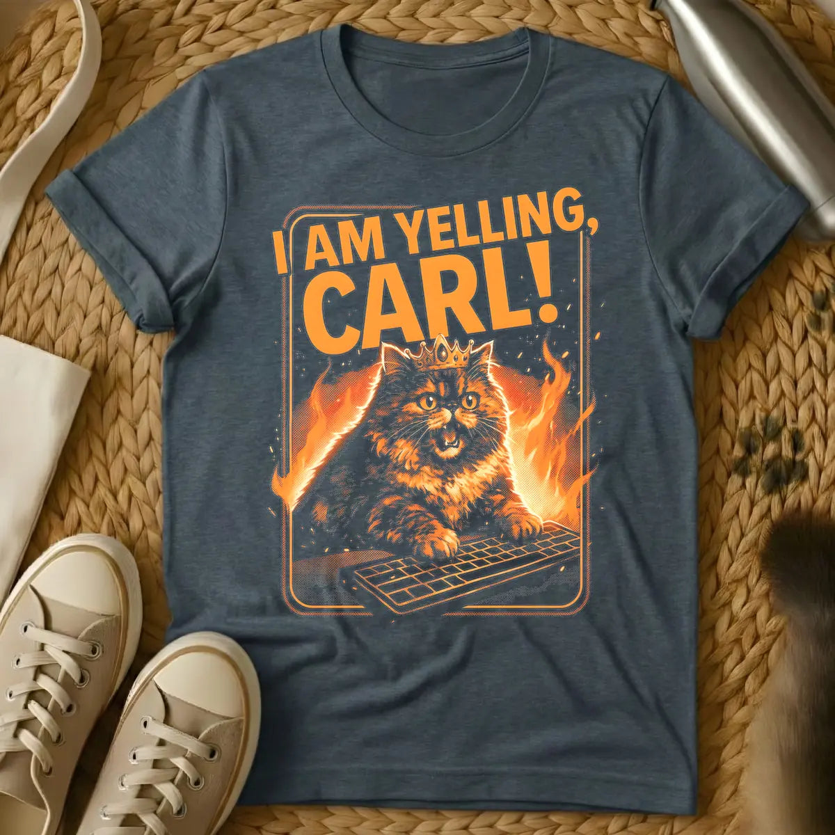 Dark Heather - Orange and black t-shirt design featuring a crowned, angry-looking cat with wide eyes and an open mouth, surrounded by flames, aggressively typing on a computer keyboard. Above the cat, the bold orange text reads "I AM YELLING, CARL!"