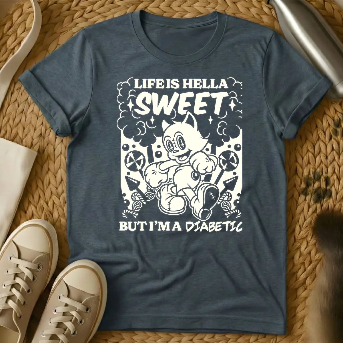 Dark Heather - Monochrome t-shirt design featuring a cheerful, running vintage cartoon cat amidst clouds, stars, lollipops, and candy canes. Above the cat, the text reads 'LIFE IS HELLA SWEET' in a bold, curvy font, with 'SWEET' being prominent. Below the cat, 'BUT I'M A DIABETIC' is written in a contrasting, handwritten style.