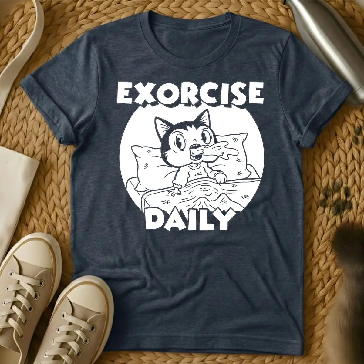 Heather Navy - T-shirt design of a cartoon cat sleeping comfortably under a blanket with a pillow. Above the cat is the word 'EXORCISE' and below is 'DAILY'.