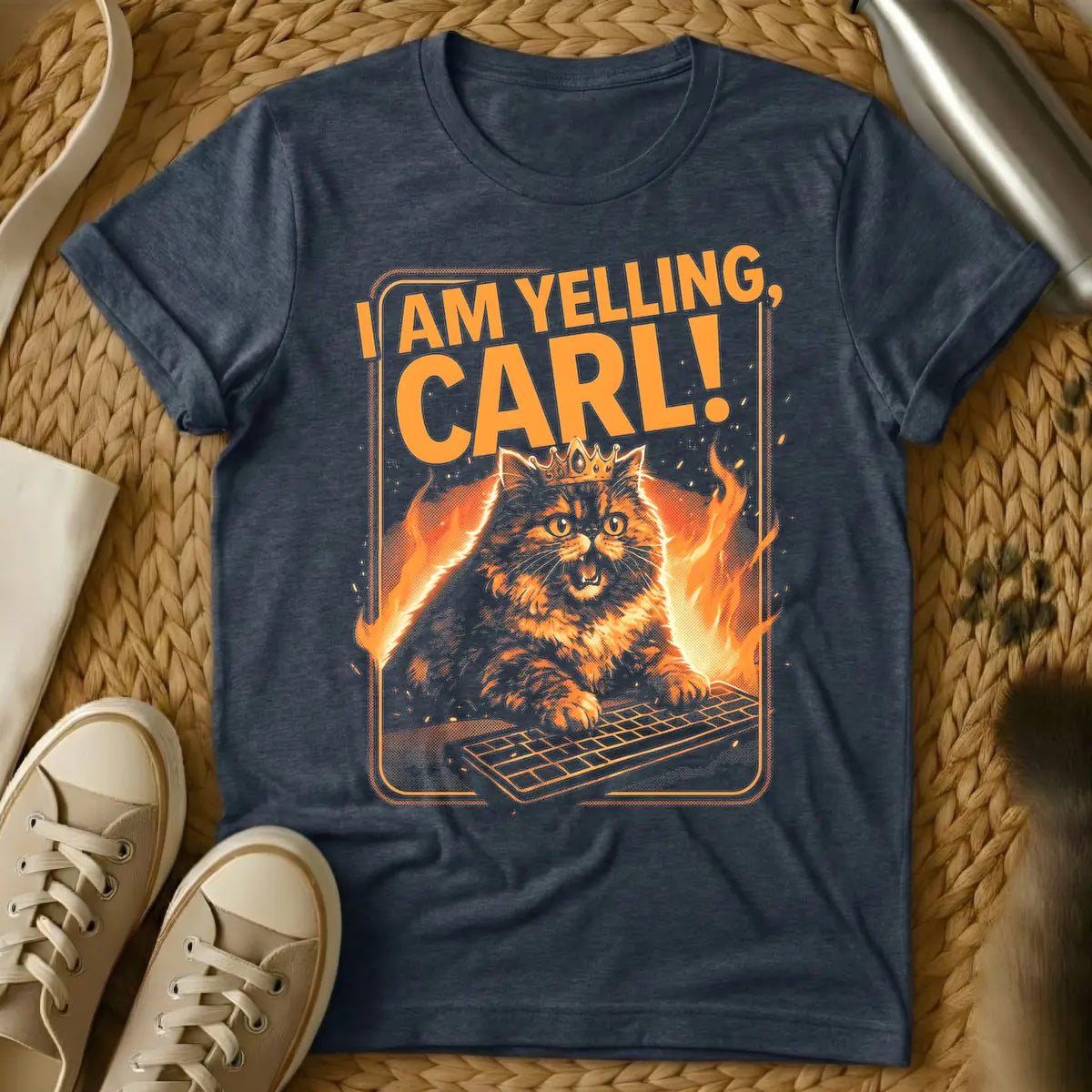 Heather Navy - Orange and black t-shirt design featuring a crowned, angry-looking cat with wide eyes and an open mouth, surrounded by flames, aggressively typing on a computer keyboard. Above the cat, the bold orange text reads "I AM YELLING, CARL!"