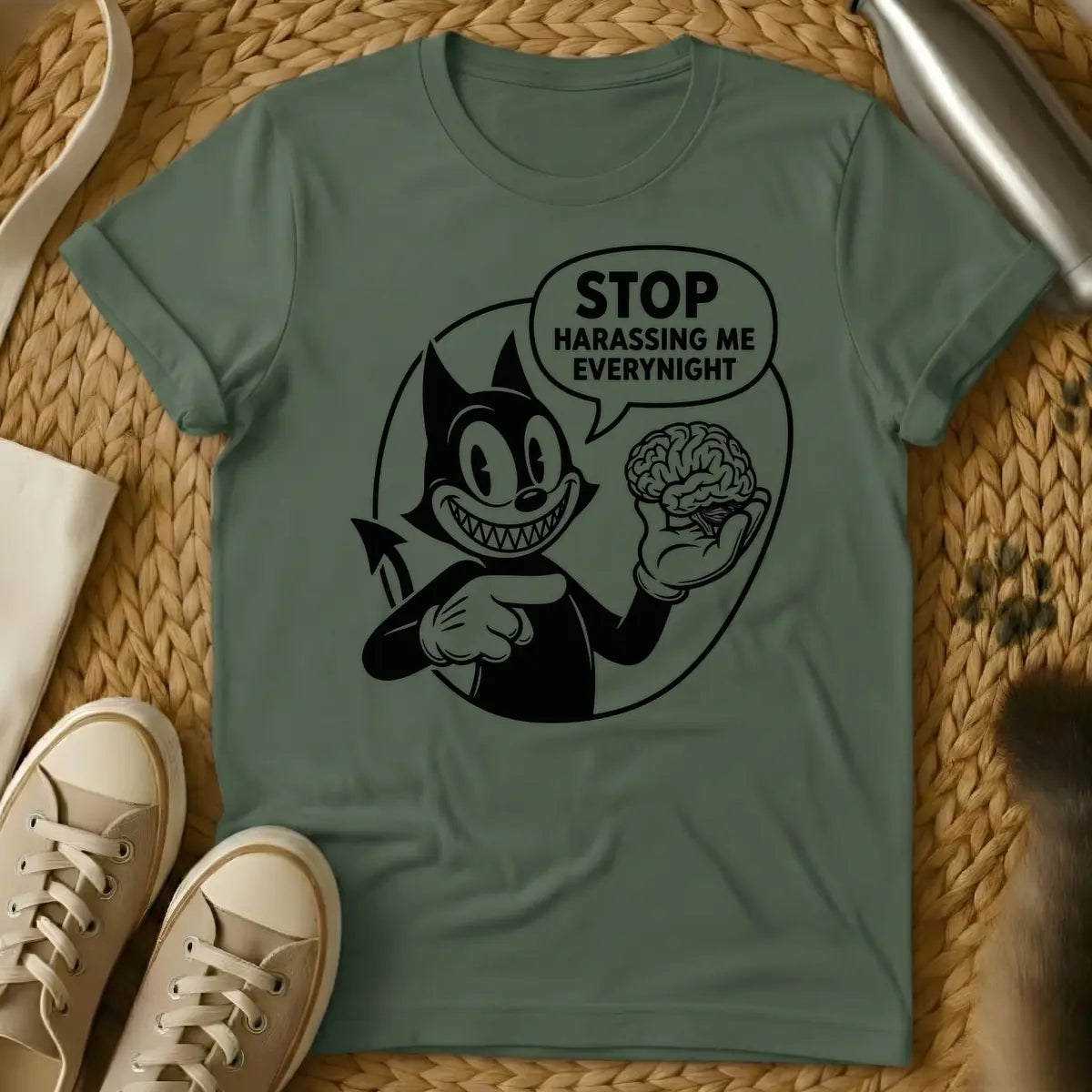 Military Green - Black and white vintage cartoon devil cat with a wide, sharp-toothed grin, holding a human brain in one hand and pointing at it, with a speech bubble that reads "STOP HARASSING ME EVERY NIGHT".