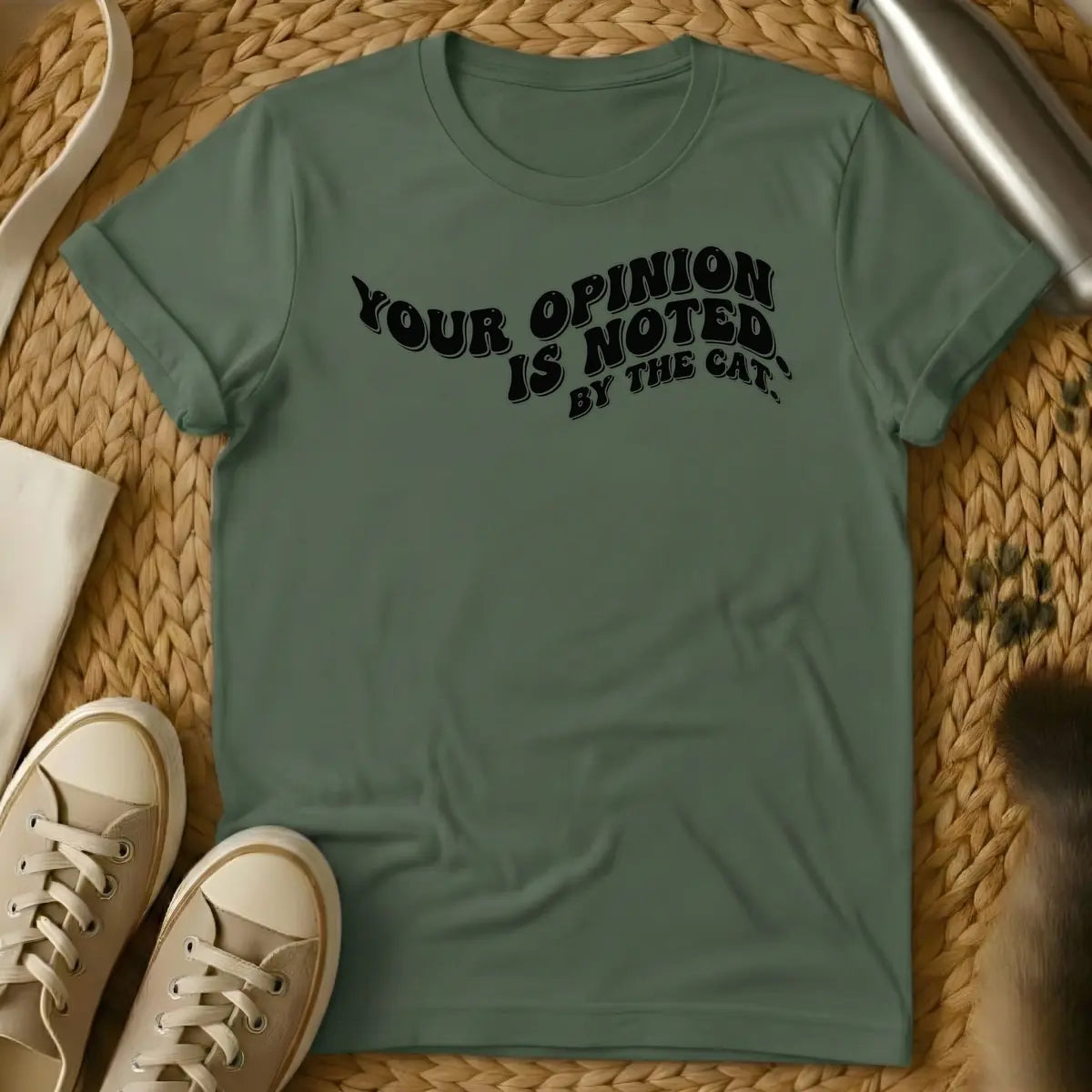 Military Green - T-shirt design featuring the phrase "YOUR OPINION IS NOTED BY THE CAT." in a cream, bubbly retro font.