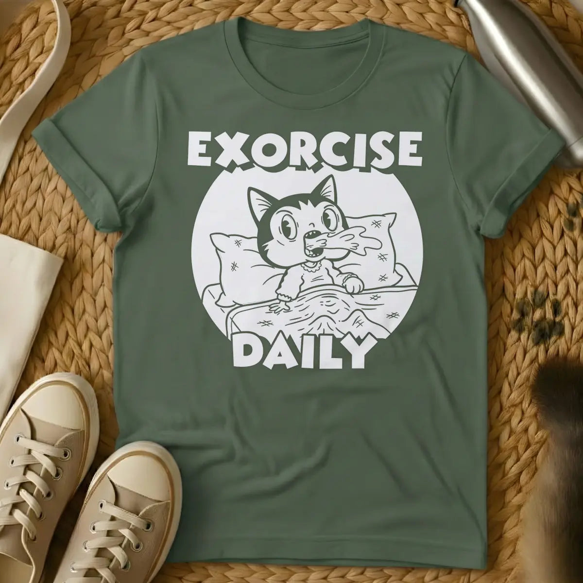 Military Green - T-shirt design of a cartoon cat sleeping comfortably under a blanket with a pillow. Above the cat is the word 'EXORCISE' and below is 'DAILY'.