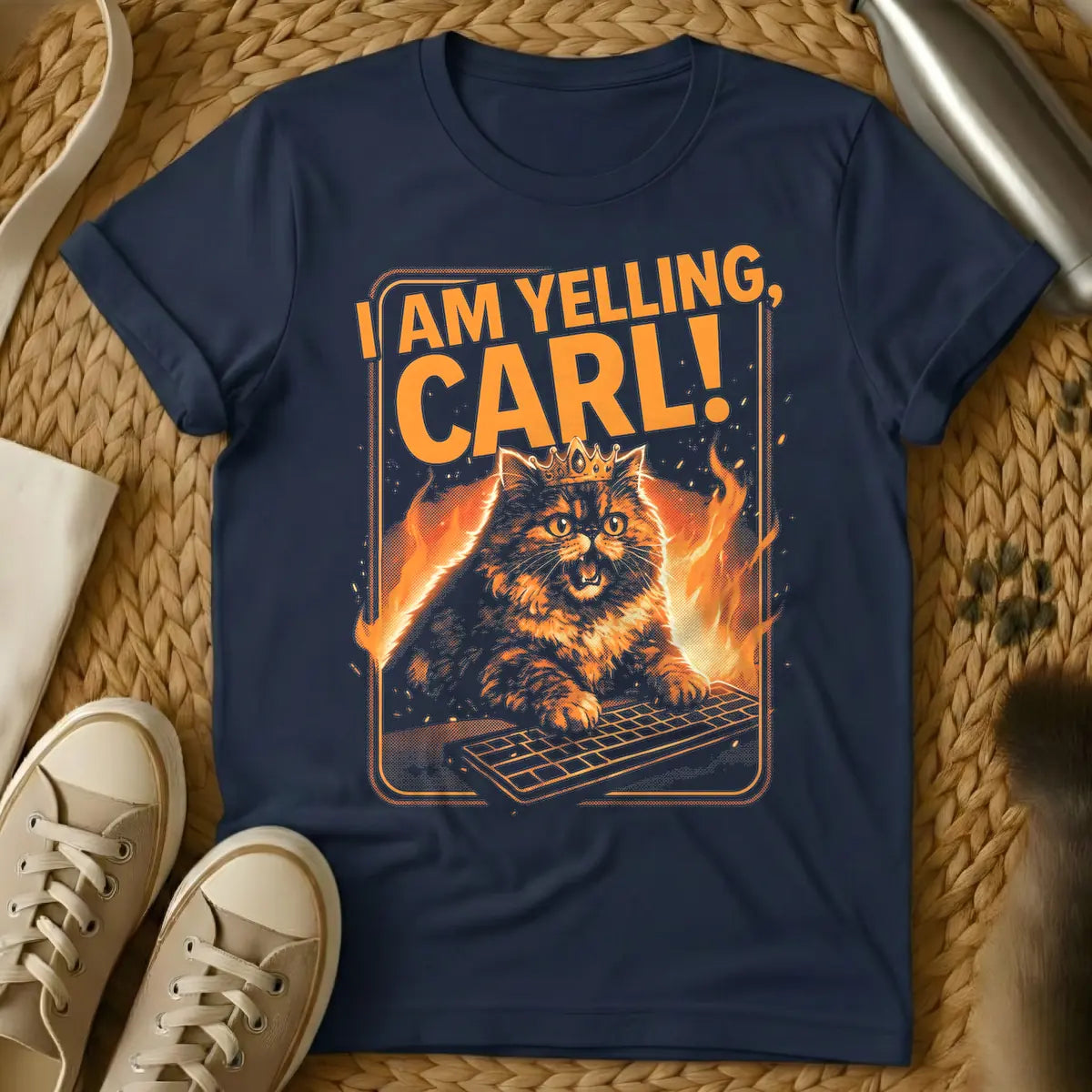 Navy - Orange and black t-shirt design featuring a crowned, angry-looking cat with wide eyes and an open mouth, surrounded by flames, aggressively typing on a computer keyboard. Above the cat, the bold orange text reads "I AM YELLING, CARL!"