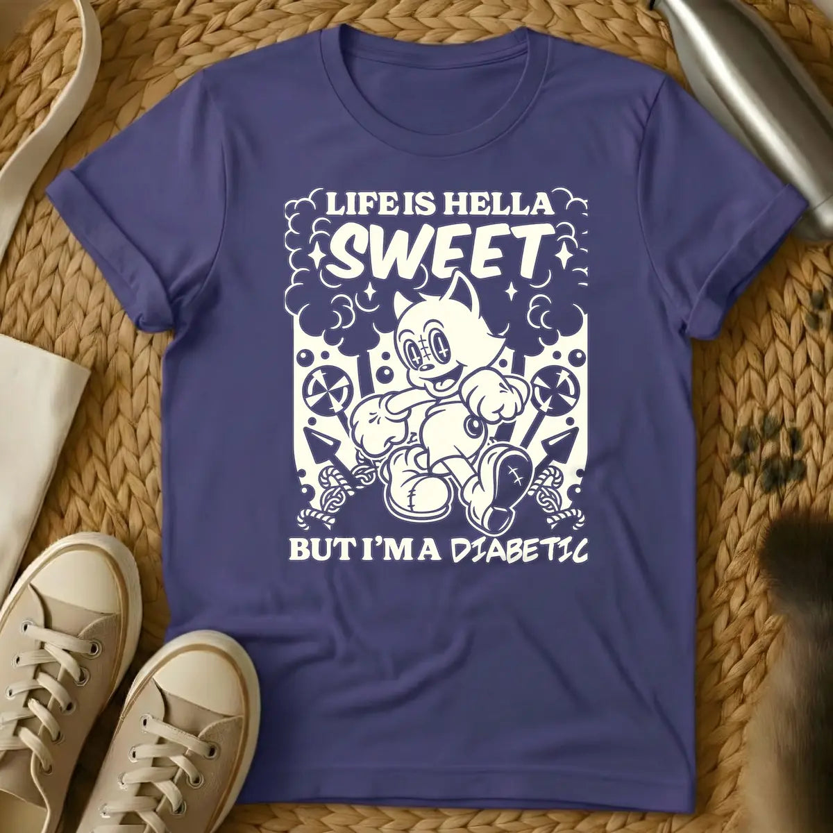 Purple - Monochrome t-shirt design featuring a cheerful, running vintage cartoon cat amidst clouds, stars, lollipops, and candy canes. Above the cat, the text reads 'LIFE IS HELLA SWEET' in a bold, curvy font, with 'SWEET' being prominent. Below the cat, 'BUT I'M A DIABETIC' is written in a contrasting, handwritten style.