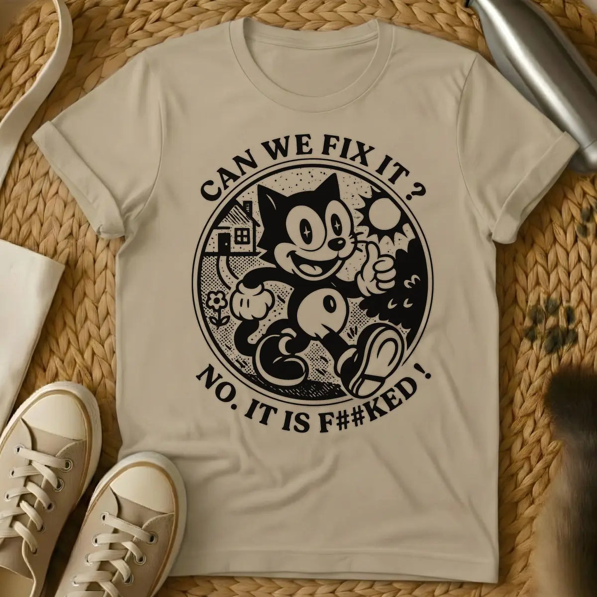 Sand - Distressed cream-colored vintage cartoon cat, similar to Felix, with star-sparkle eyes, smiling and giving a thumbs up inside a circular border with a small house, flower, and sunburst. Arched text above the circle reads "CAN WE FIX IT?" and arched text below reads "NO. IT IS F##KED!".