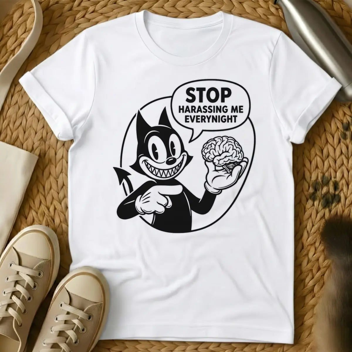 White - Black and white vintage cartoon devil cat with a wide, sharp-toothed grin, holding a human brain in one hand and pointing at it, with a speech bubble that reads "STOP HARASSING ME EVERY NIGHT".