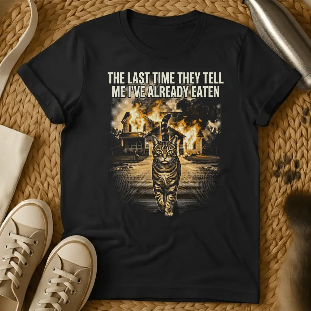 Black - Black t-shirt with cat walking away from burning house and text "THE LAST TIME THEY TELL ME I'VE ALREADY EATEN" in humorous meme style
