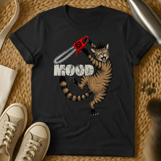 Black - Cartoon cat holding red chainsaw with "MOOD" text on olive green t-shirt, displayed flat lay with sneakers
