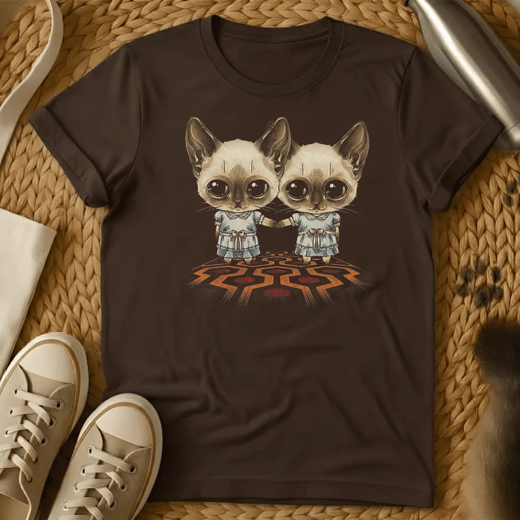 Dark Chocolate - Dark heather t-shirt with two wide-eyed Siamese cats in frilly dresses holding hands on a geometric patterned carpet, creepy twin horror design