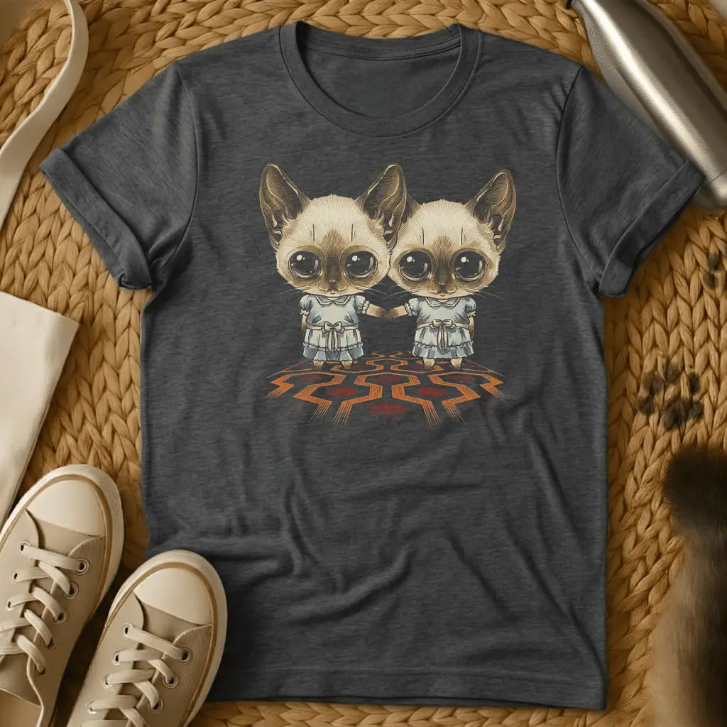 Dark Heather - Dark heather t-shirt with two wide-eyed Siamese cats in frilly dresses holding hands on a geometric patterned carpet, creepy twin horror design