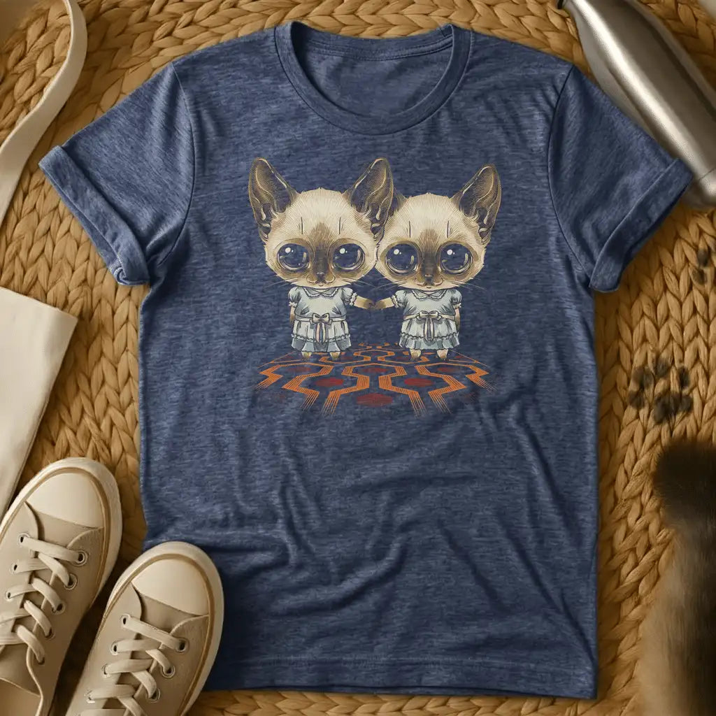 Heather Navy - Dark heather t-shirt with two wide-eyed Siamese cats in frilly dresses holding hands on a geometric patterned carpet, creepy twin horror design