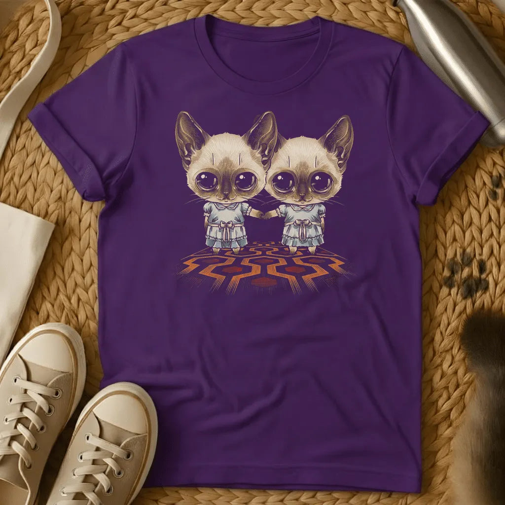 Purple - Dark heather t-shirt with two wide-eyed Siamese cats in frilly dresses holding hands on a geometric patterned carpet, creepy twin horror design