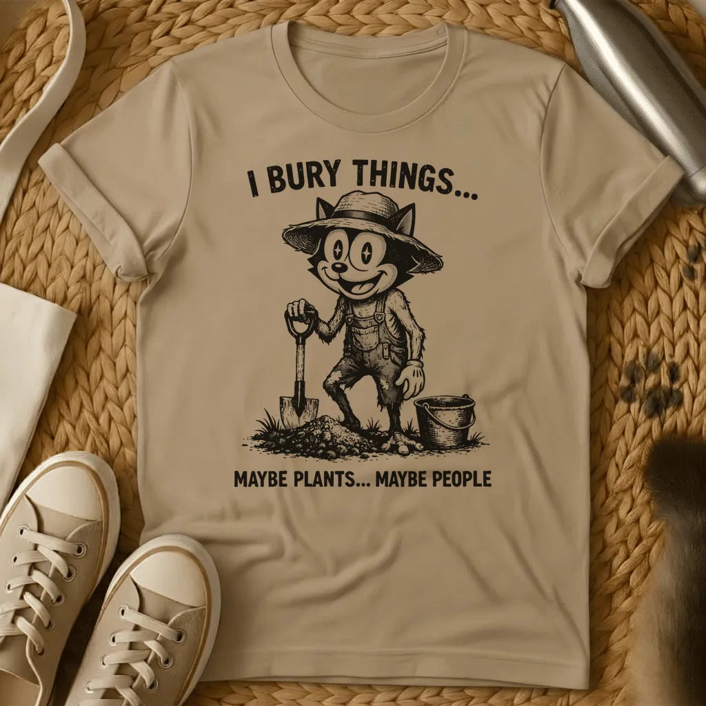 Sand - Vintage-style graphic tee featuring a grinning cat character in gardening clothes holding a shovel with text "I bury things... maybe plants... maybe p
