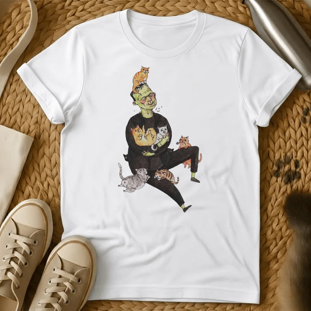 White - Frankenstein's monster juggling colorful cats on a sage green t-shirt with whimsical cartoon illustration style