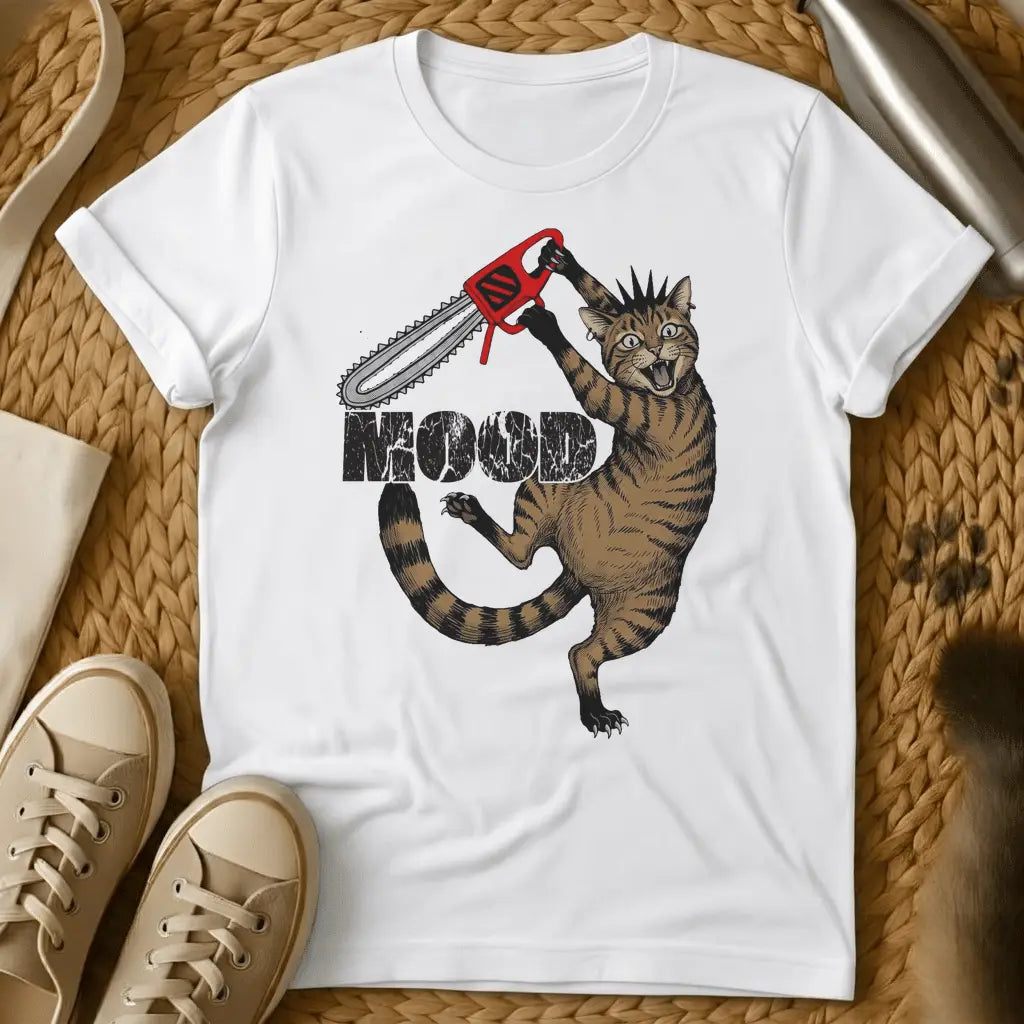 White - Cartoon cat holding red chainsaw with "MOOD" text on olive green t-shirt, displayed flat lay with sneakers